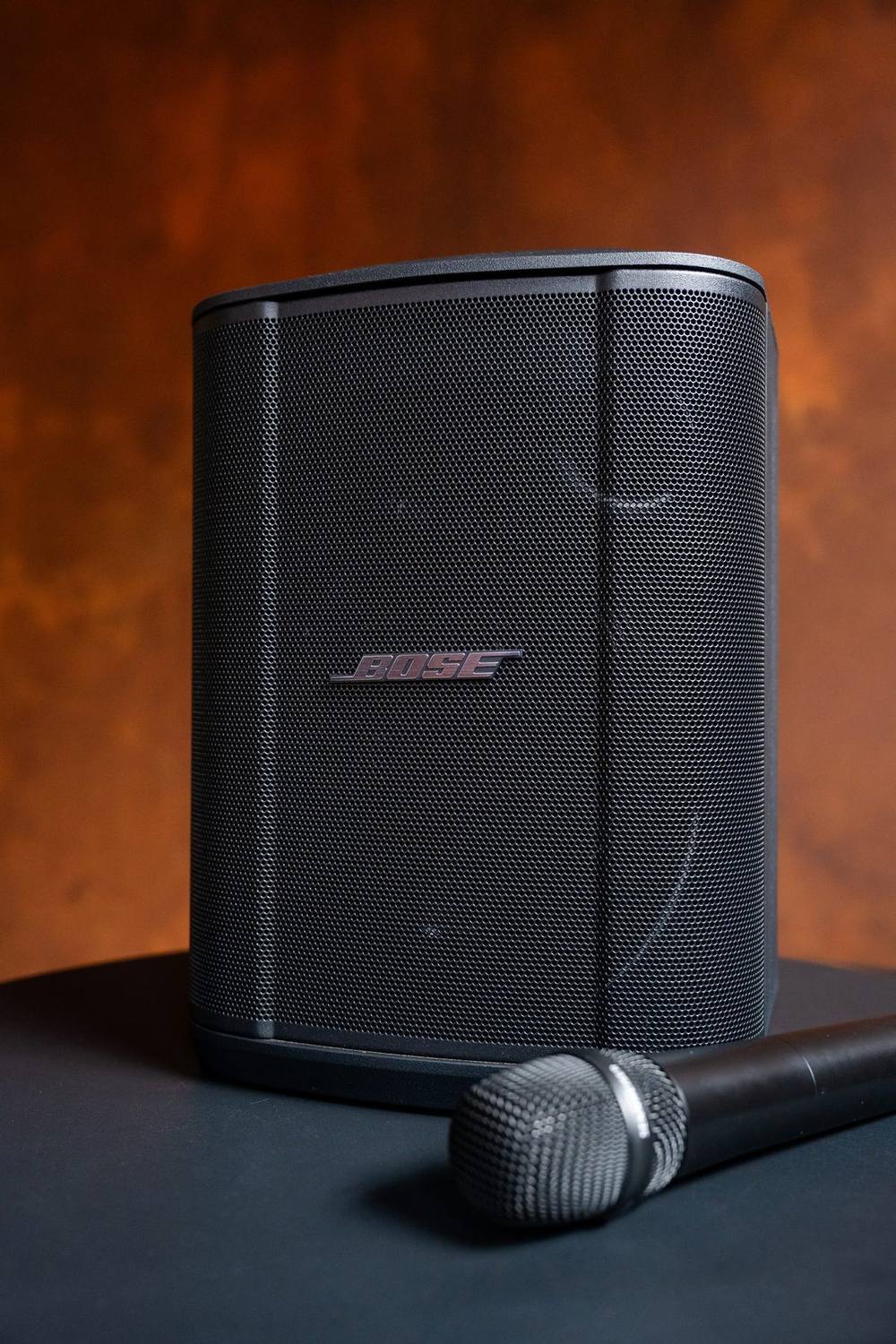 Katie’s portable Bose PA speaker with a wireless microphone resting in front of it
